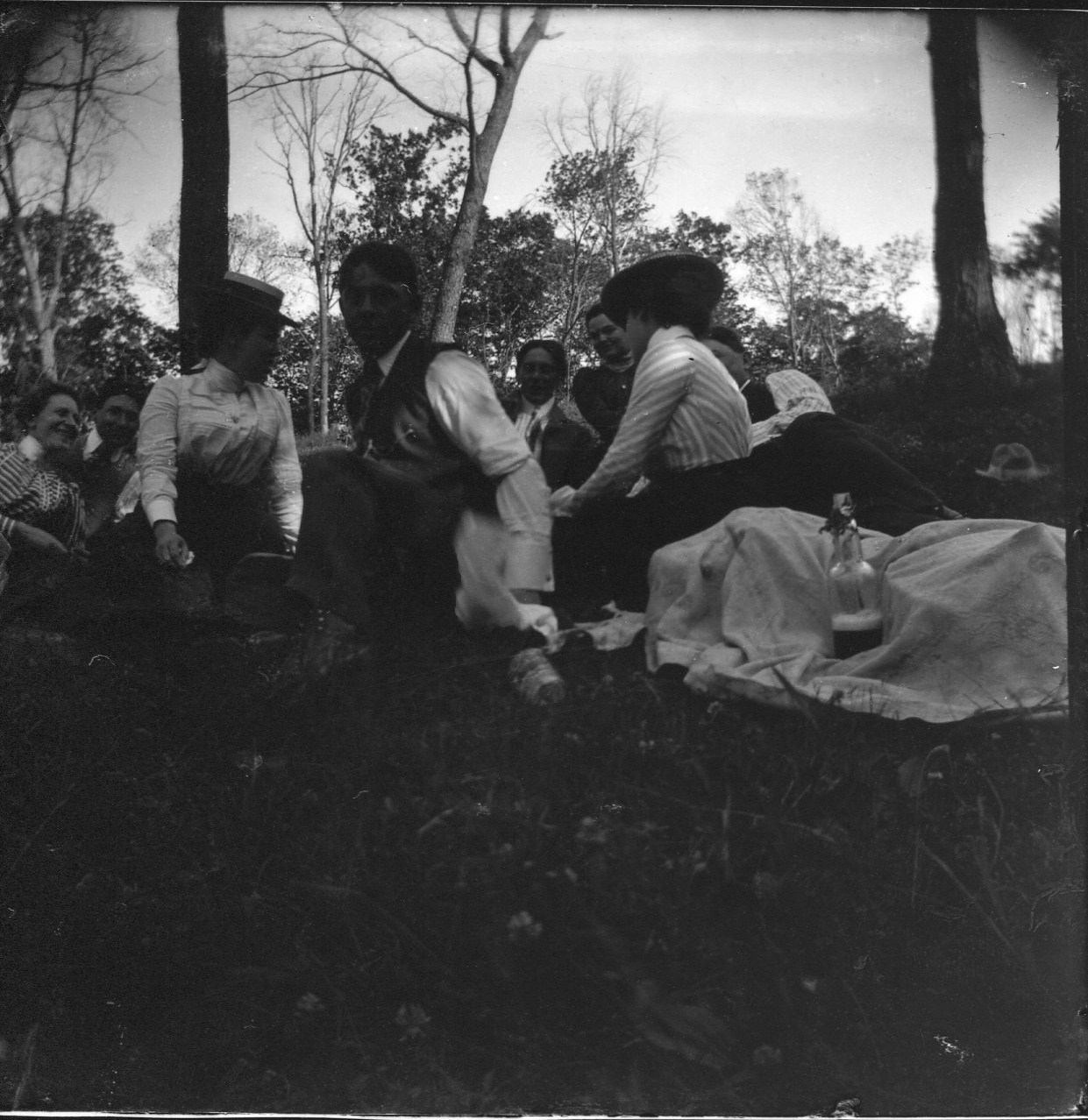 photo of Unidentified Men and Women Sitting at a Picnic