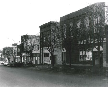Photo of buildings on South side of First Street W. Photographed 1990 by Barbara Beving Long.