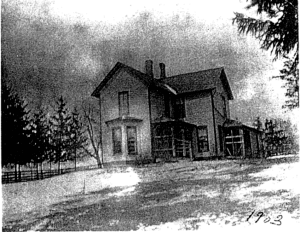 Black and white photo of a farmhouse built in the traditional American style in the 19th century