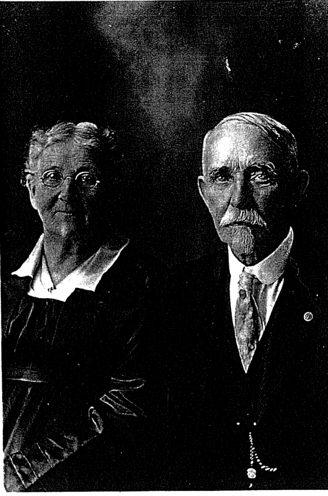 Family photo of Amos Strother and Ellen Strother in their 80s. Amos has a broad mustache and neatly combed goatee, and Ellen wears glasses