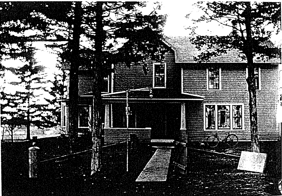 Black and white photo of a farmhouse from the front.