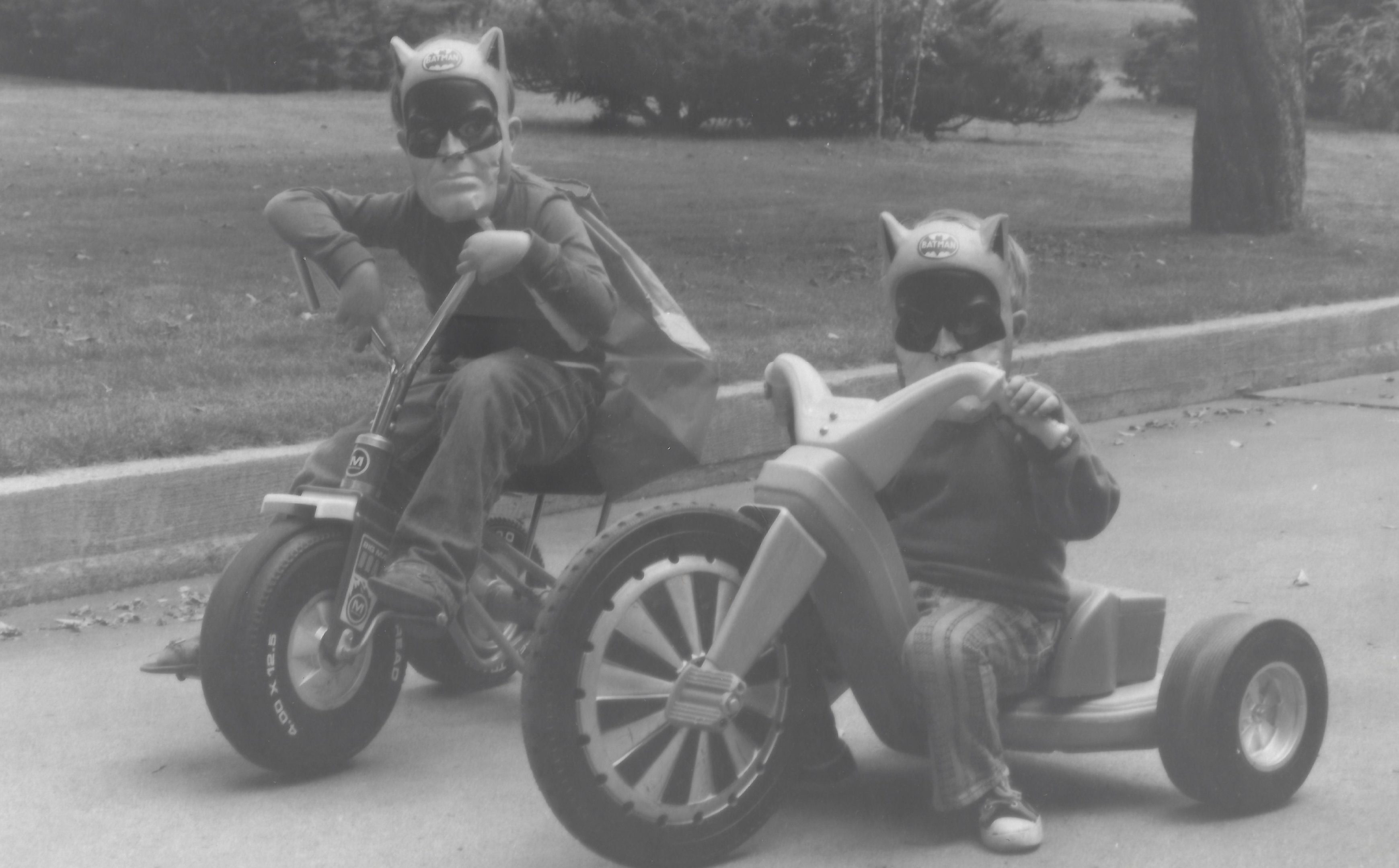 Photo of two boys riding their Big Wheels dressed as superheroes, 1970s