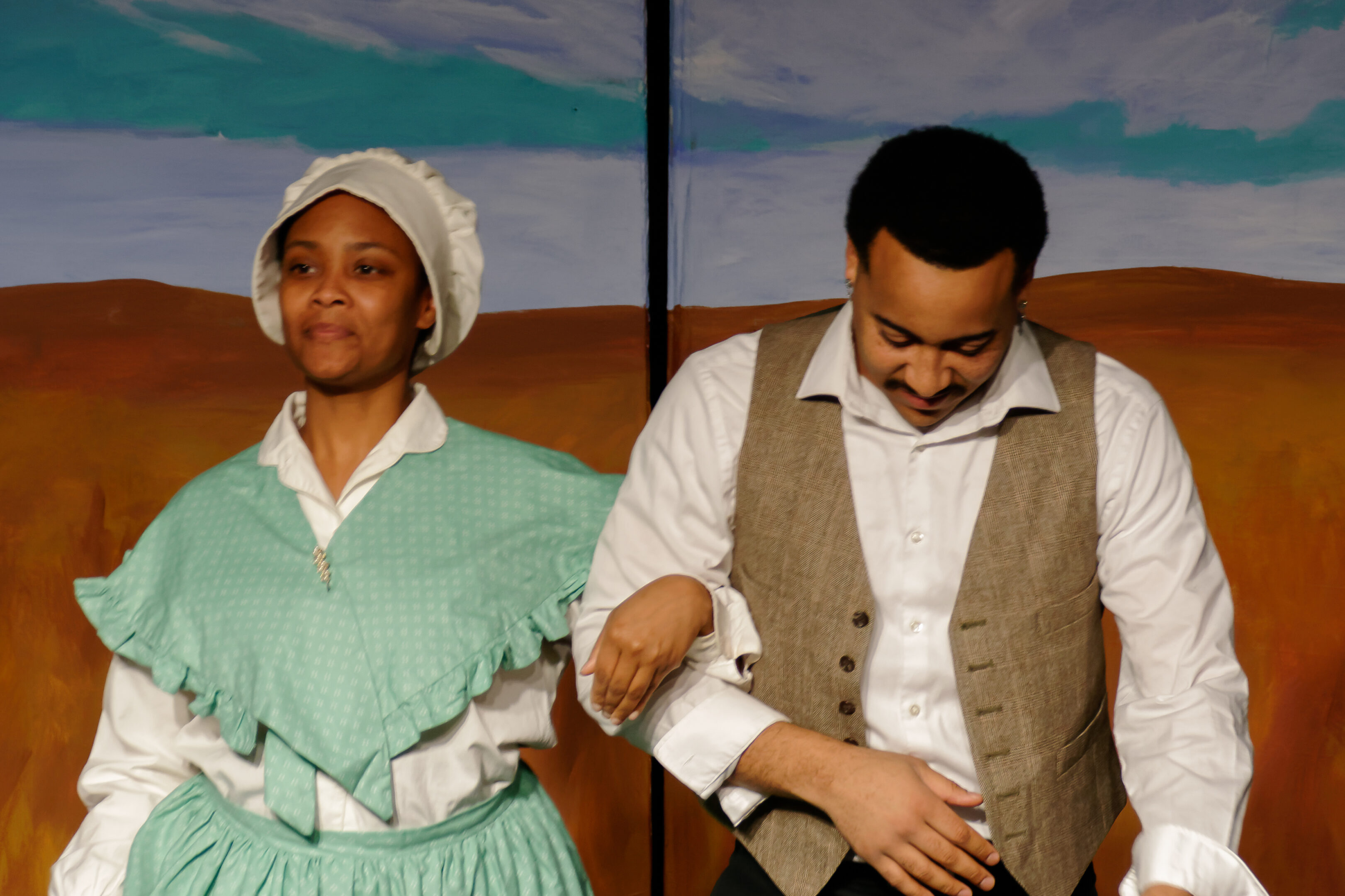 2023-Treasure Play-Tiyah Western as restauranteur and baker Mrs. J. M. Ruff links arms with Deon Nelson as barber James Ruff