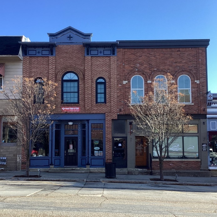 2-story red brick commercial buildings with large windows on ground floor and tall thin windows on second floor