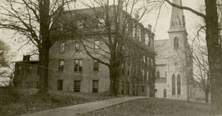 1910 black and white photo of Cornell College's "Old Sem" building.  A rectangular 4-story brick building.  The fourth floor is a mansard style roof.