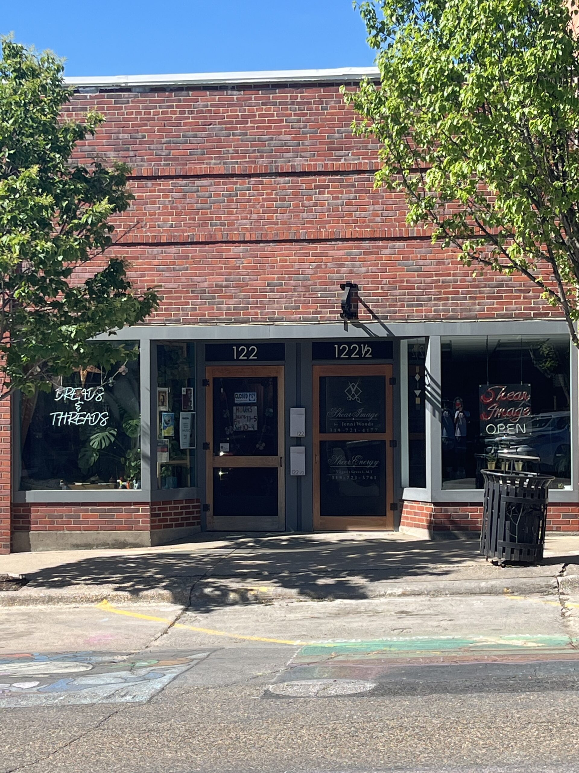 A photo of a brick building housing Dreads & Threads a boutique and dreadlock salon.