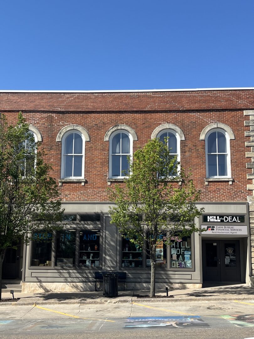 Photo of red brick building with arched upper story windows housing Hill of a Deal.