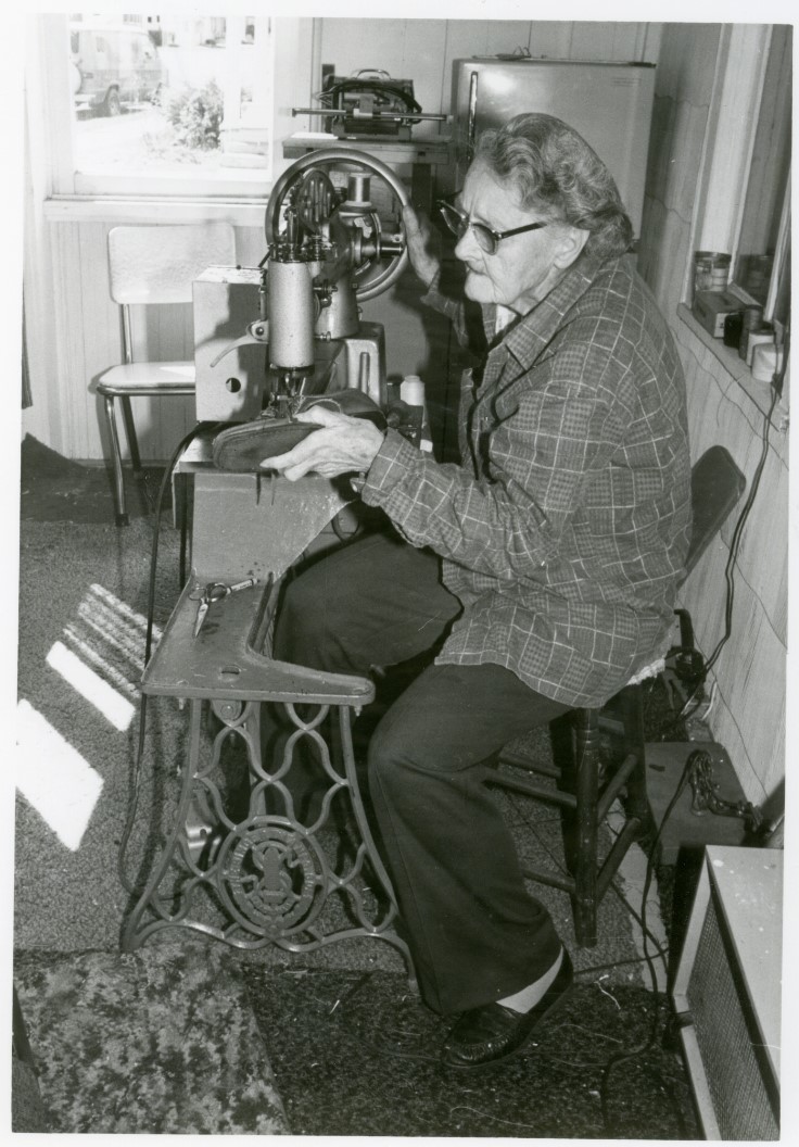 Black and white photo of Lora Vargason repairing a shoe.