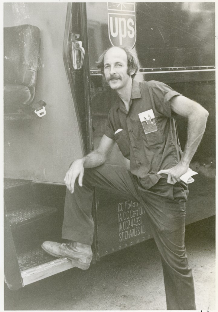 Black and white photo of Bob Stuckland putting a foot up on his UPS truck.