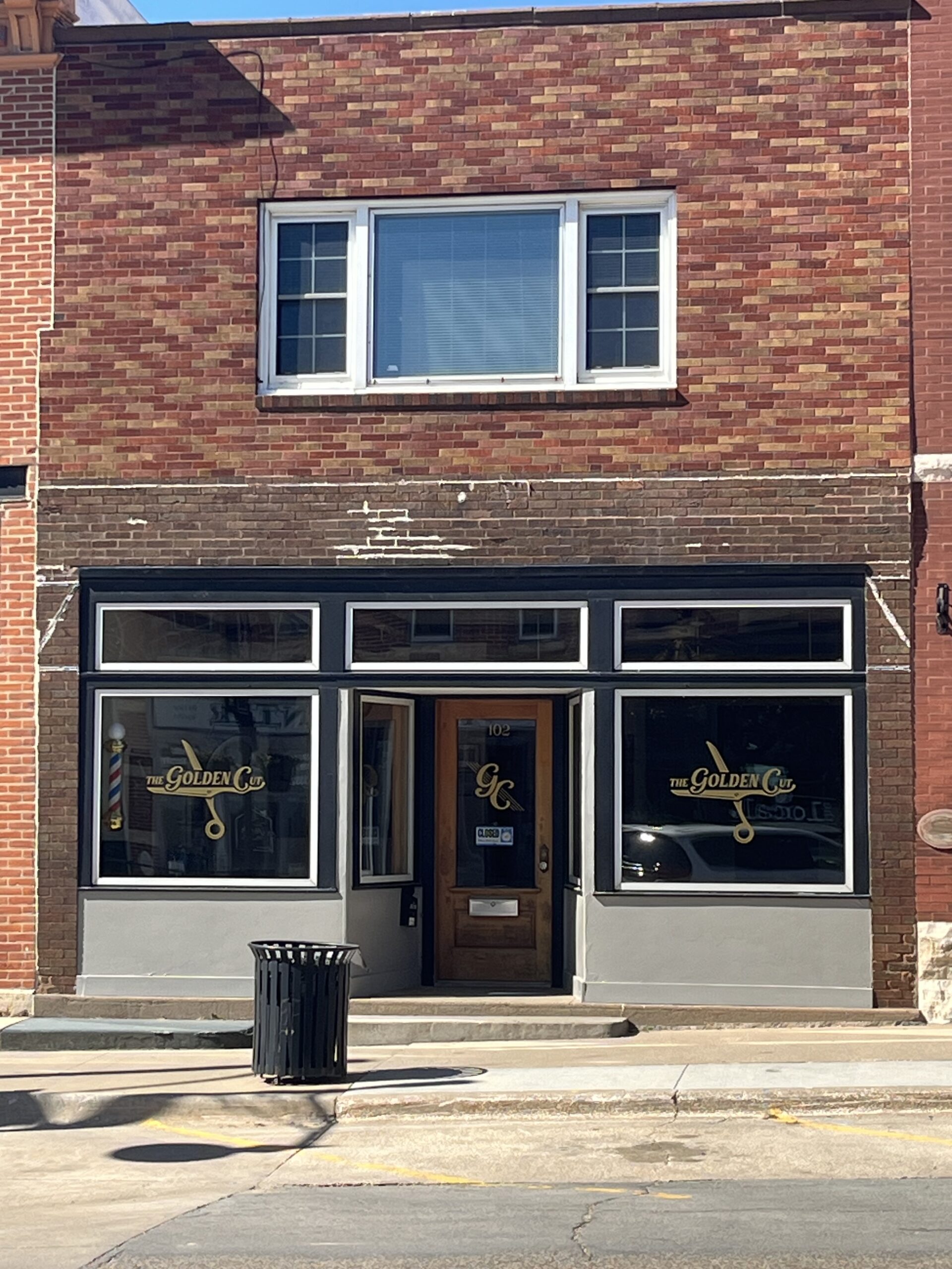 The Golden Cut is a barber shop in a red brick building.