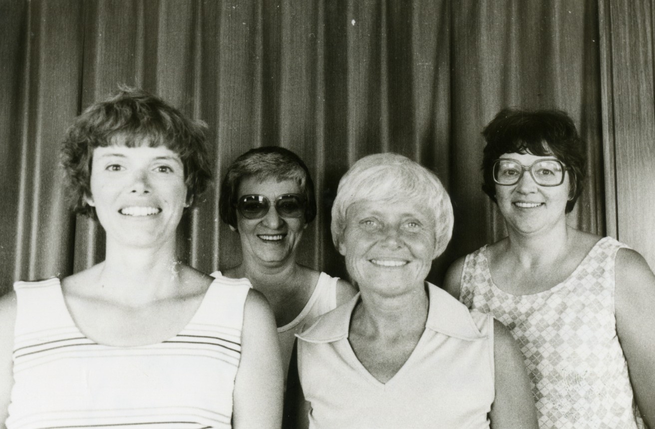 A black and white photo of 4 woman smiling after a golf tournament.