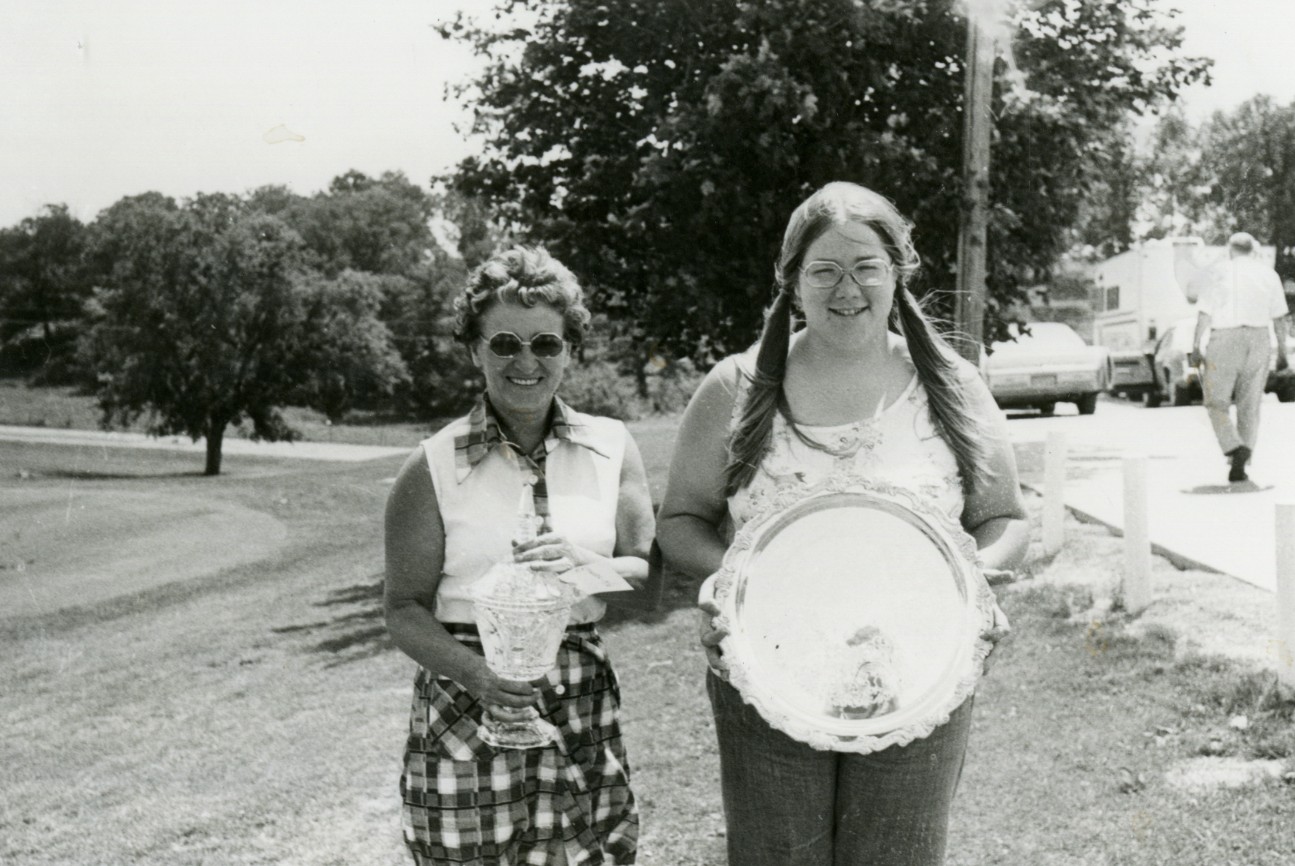 Photo of Pauline Wagamen and Cindy Brennamen posing with their Hillcrest Open trophies.